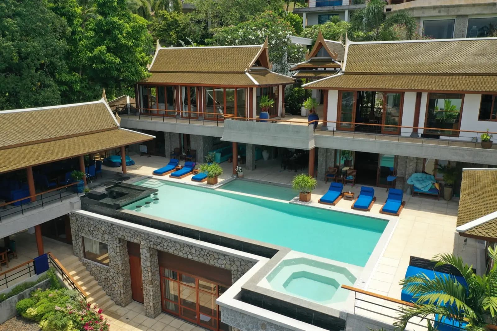 Traditional Thai pavilions rising above a long aqua pool and spa
