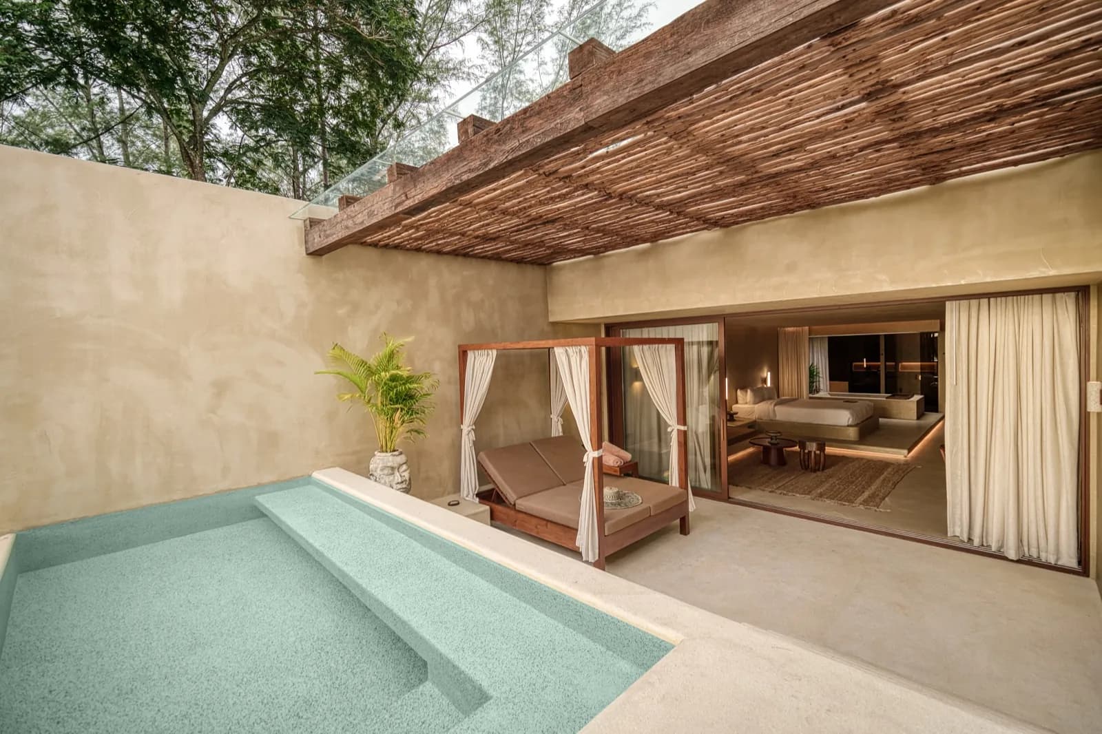 Private plunge pool with steps leading to a canopy daybed and open suite