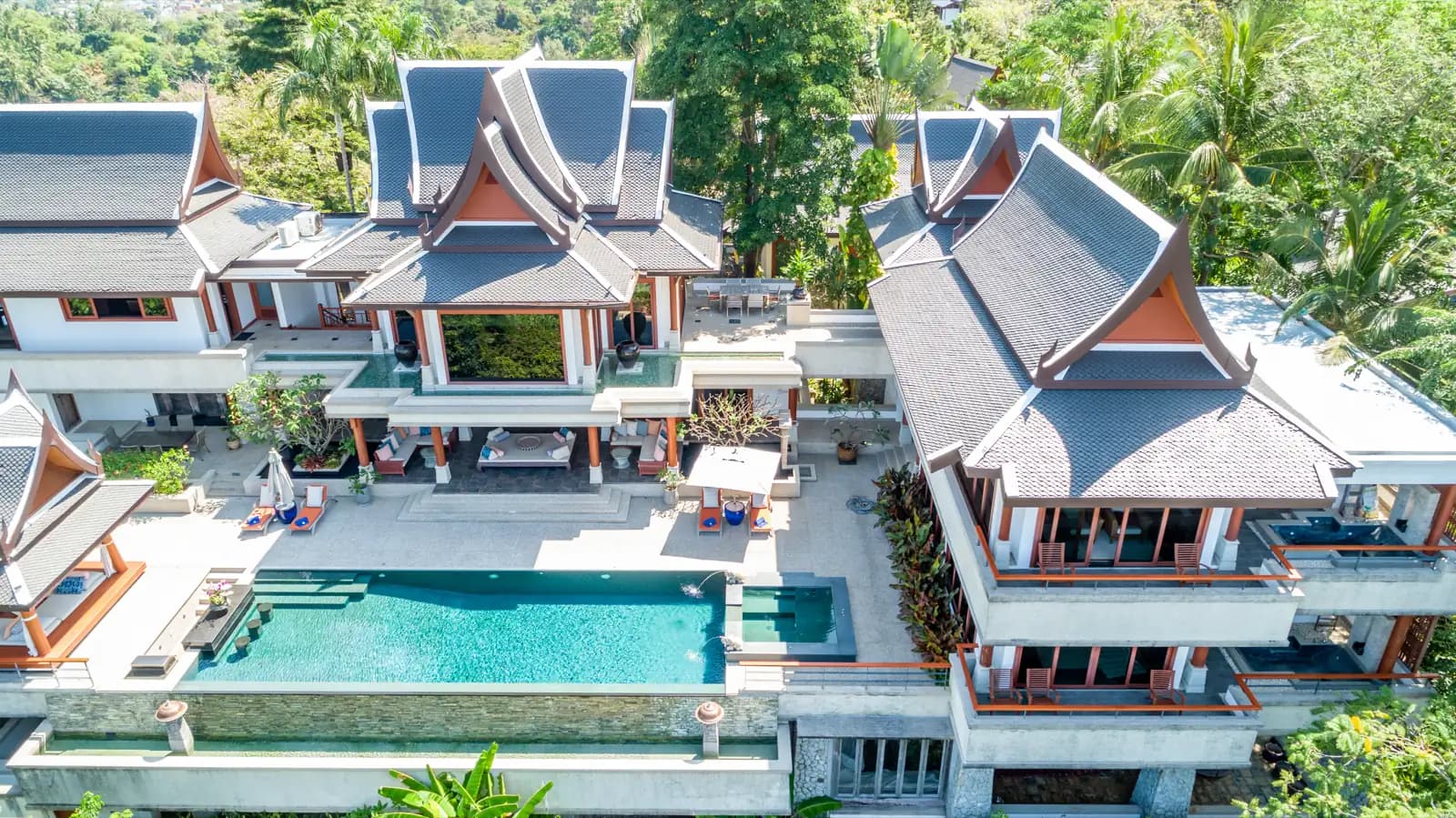 Aerial view of a tiered Thai villa estate with its turquoise infinity pool