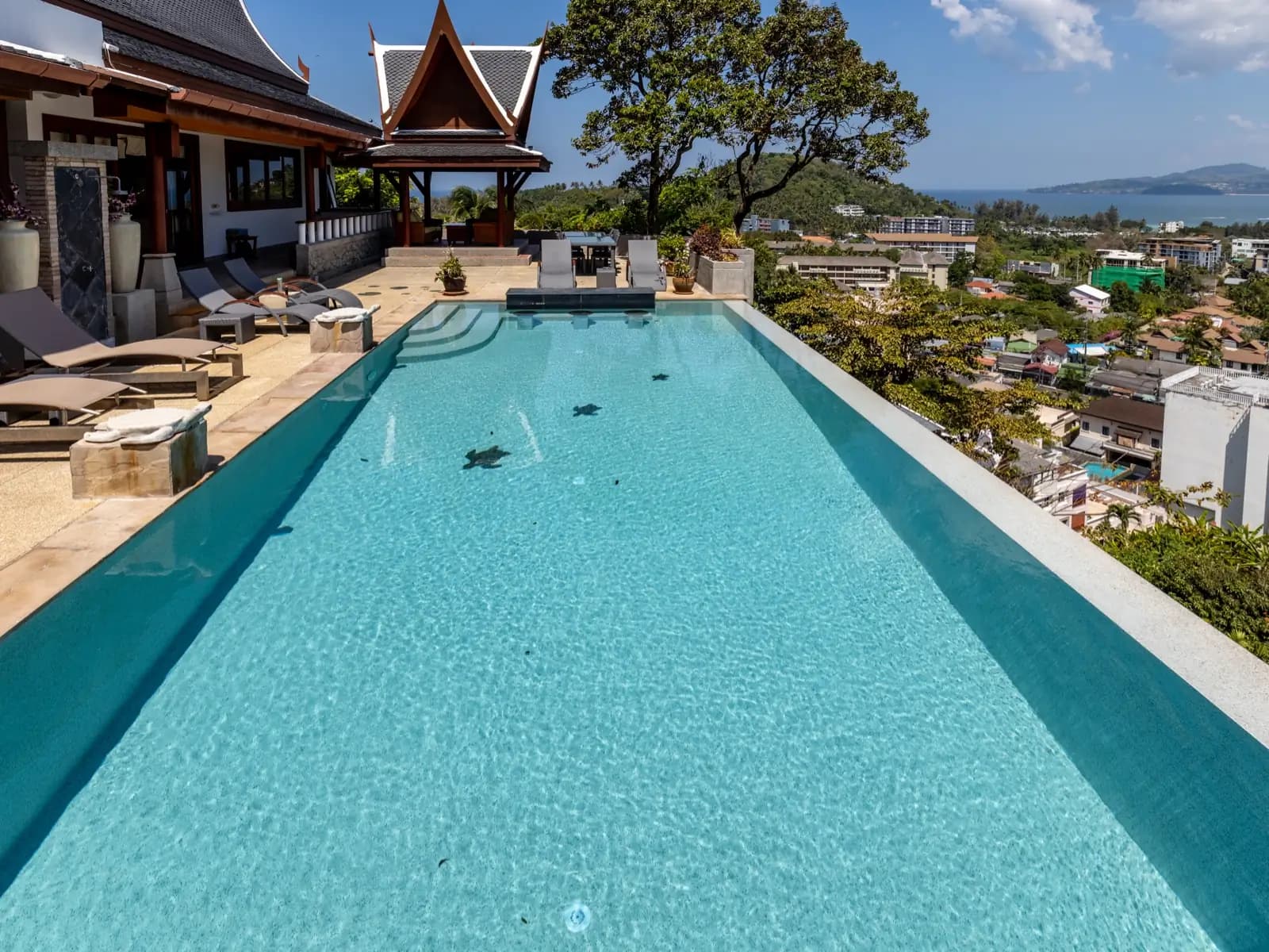 Lap pool with starfish mosaics leading to a Thai-roofed pavilion