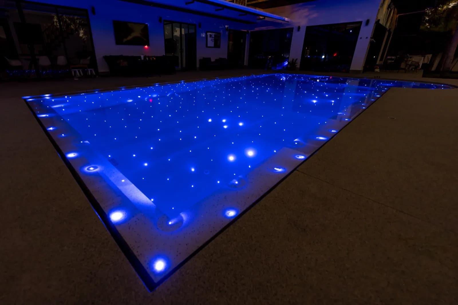 Close view of deep-blue pool water dotted with fibre-optic star lights