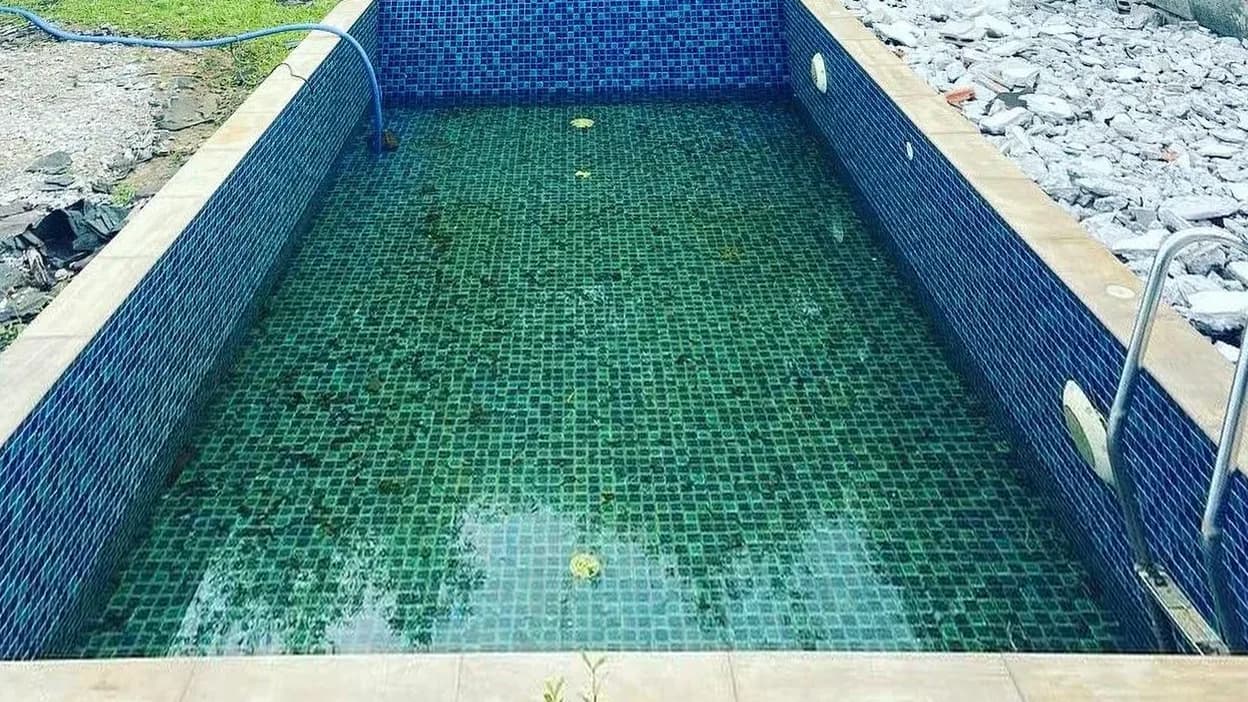 Pool with in-water bar stools before renovation