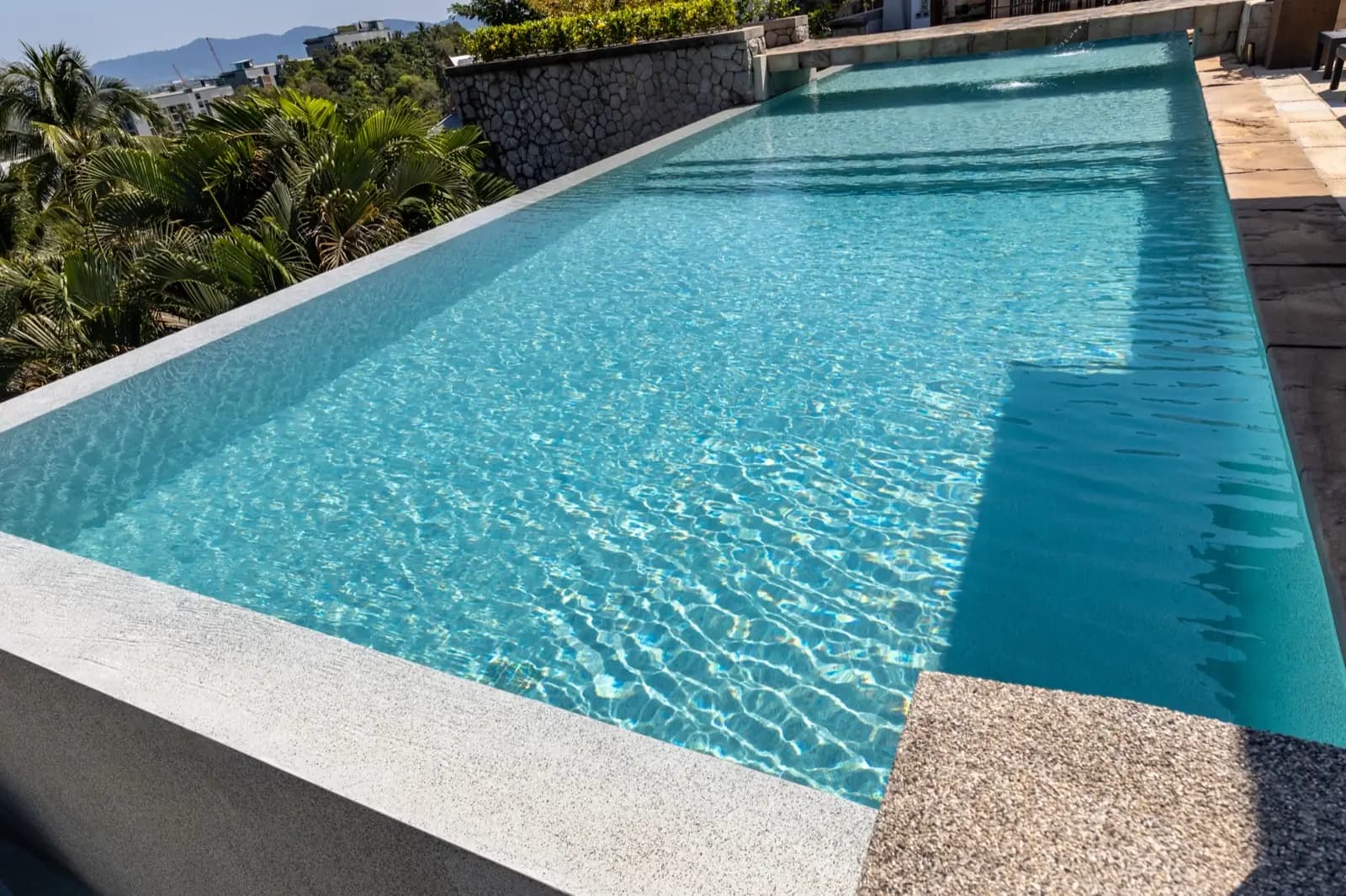 Close view of sunlit ripples over a light-aqua pebble finish