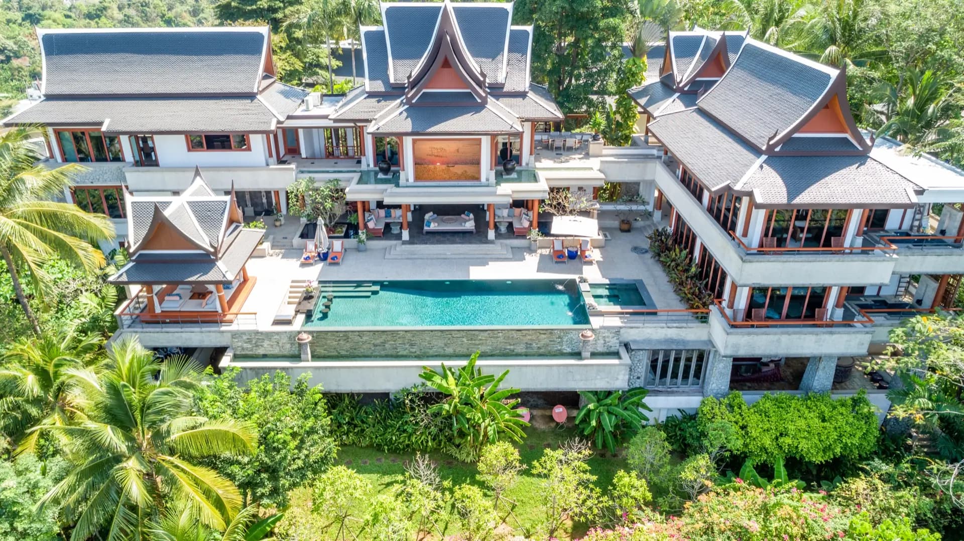 Drone view of a Thai-style hillside estate with its long infinity pool