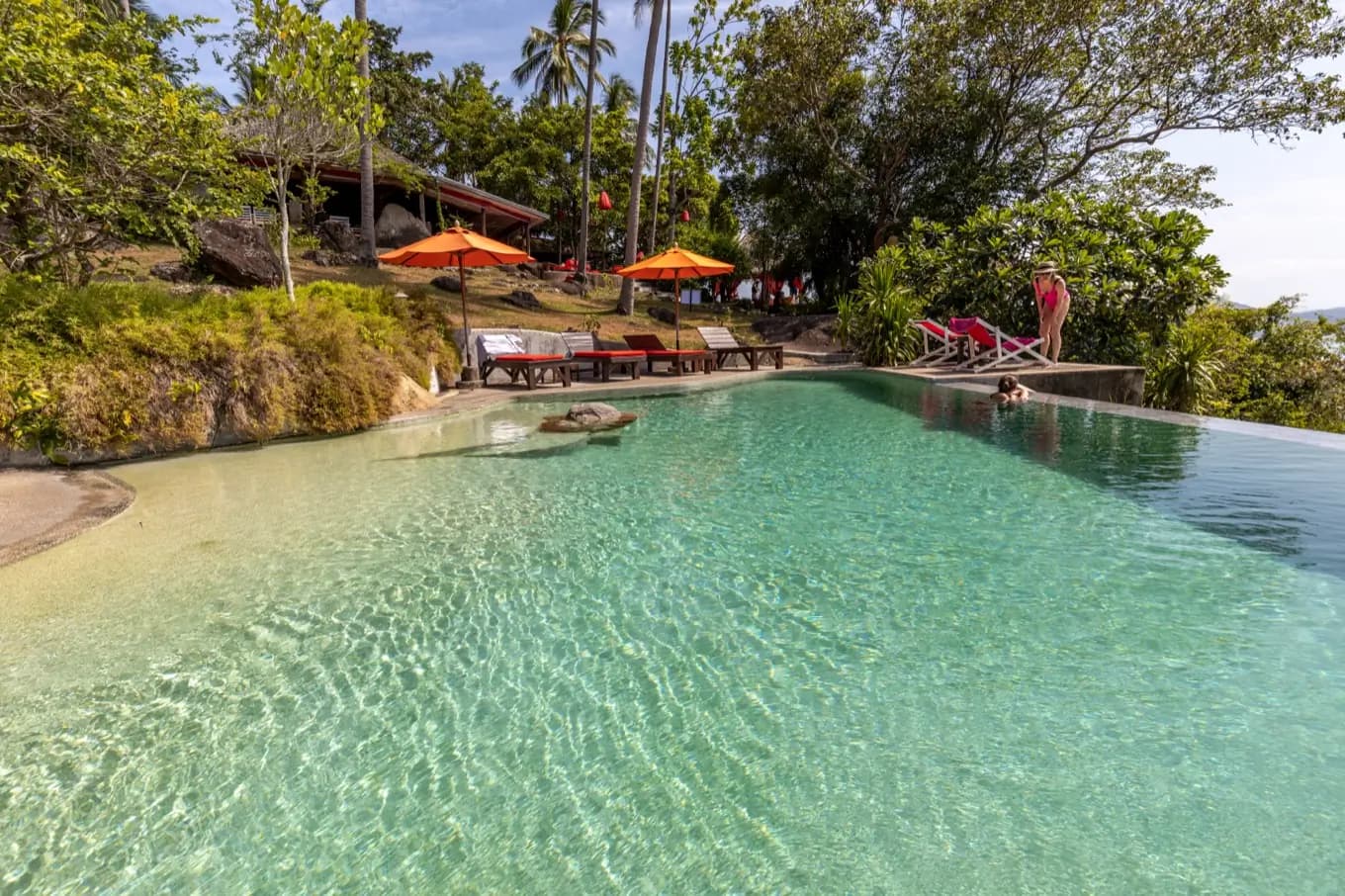 Crystal-clear turquoise shallows over a light pebble finish in a resort pool